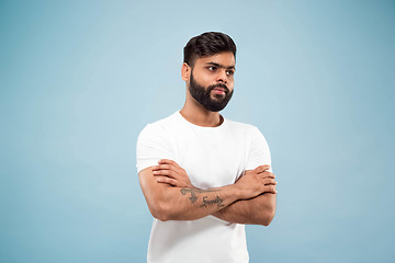 Image showing Half-length close up portrait of young man on blue background.