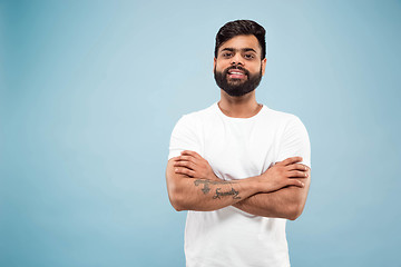 Image showing Half-length close up portrait of young man on blue background.