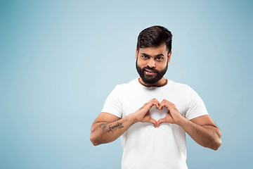 Image showing Half-length close up portrait of young man on blue background.