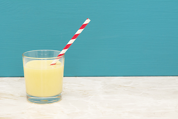 Image showing Tasty banana milkshake with a straw in a glass 