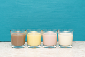 Image showing Chocolate, banana and strawberry milkshakes and milk in tumblers