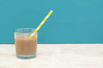 Image showing Thick chocolate milkshake with a straw in a glass