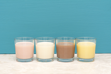 Image showing Flavoured milkshakes and fresh creamy milk in glass tumblers