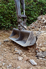 Image showing Metal digger bucket resting on broken concrete and bricks