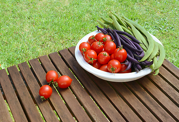 Image showing Red tomatoes with green and purple beans in a dish