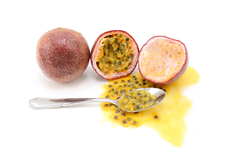 Image showing Whole and halved passion fruits ready to eat with a spoon