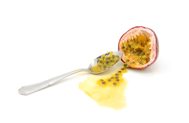 Image showing Scooping out pulp from half a passion fruit with a spoon