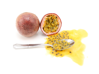 Image showing Whole passion fruit and half-eaten cross section with spoon