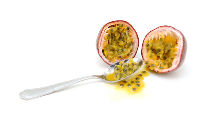 Image showing Spoon scooping out pulp and seeds from a passion fruit 