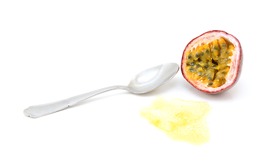 Image showing Half passion fruit showing yellow pulp and seeds with spoon