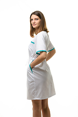 Image showing Girl in a white medical gown turned and looked into the frame, isolated on white background