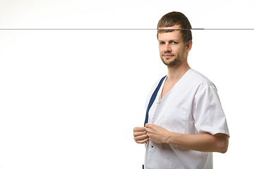 Image showing Doctor fastening buttons on medical shirt isolated on white background