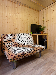 Image showing Fragment of the interior of a small living space, in the corner there is a computer table, next to a sofa