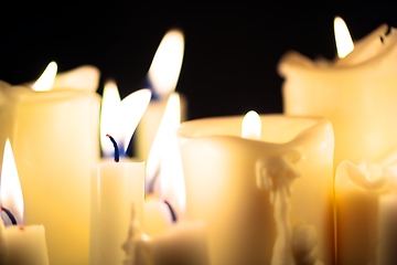 Image showing Candles glowing against dark background