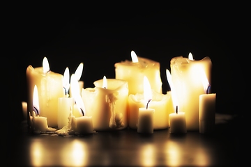 Image showing Candles glowing against dark background