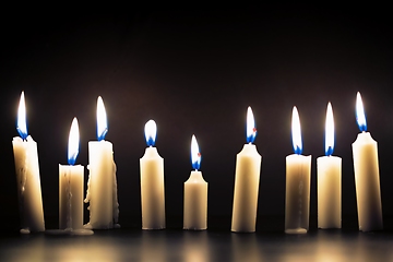 Image showing Candles glowing against dark background