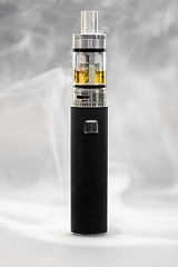 Image showing Electronic cigarette against background full of smoke