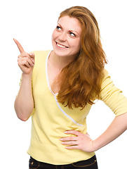 Image showing Portrait of a young woman pointing to the left