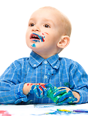 Image showing Little boy is playing with paints