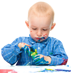 Image showing Little boy is playing with paints