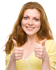 Image showing Woman is showing thumb up gesture