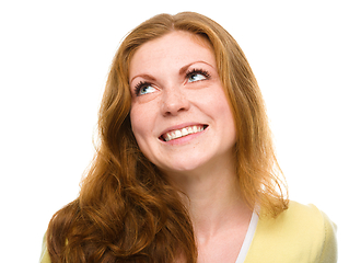 Image showing Young happy woman is looking up and smile