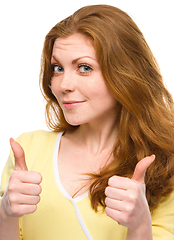 Image showing Woman is showing thumb up gesture