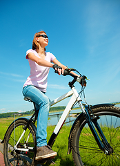 Image showing Young woman is sitting on her bicycle