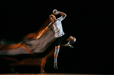 Image showing Young handball player against dark studio background in mixed light