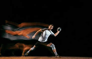 Image showing Young handball player against dark studio background in mixed light