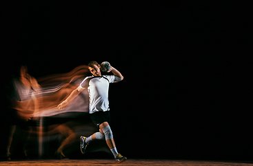 Image showing Young handball player against dark studio background in mixed light