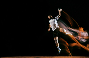 Image showing Young handball player against dark studio background in mixed light