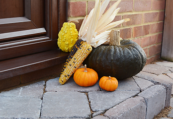 Image showing Green pumpkin with Indian corn and ornamental gourds on doorstep