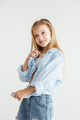 Image showing Little smiling girl posing in casual clothes on white studio background