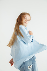 Image showing Little smiling girl posing in casual clothes on white studio background