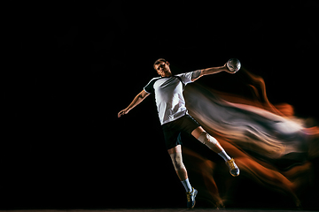 Image showing Young handball player against dark studio background in mixed light