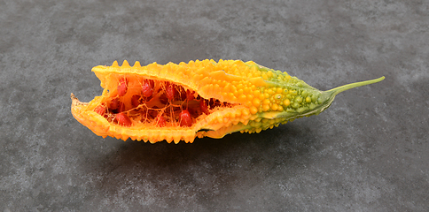 Image showing Orange bitter gourd, with ridged flesh, split open