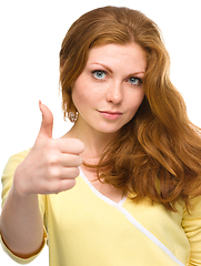 Image showing Woman is showing thumb up gesture