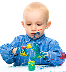 Image showing Little boy is playing with paints