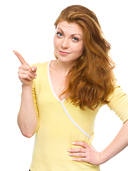 Image showing Portrait of a young woman pointing to the right