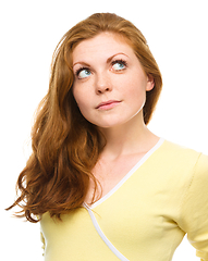 Image showing Young happy woman is looking up and smile