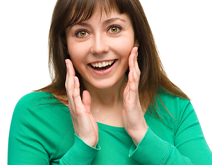 Image showing Woman is holding her face in astonishment