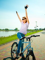 Image showing Young woman is sitting on her bicycle