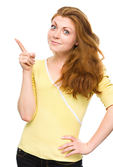 Image showing Portrait of a young woman pointing to the left
