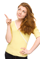 Image showing Portrait of a young woman pointing to the left