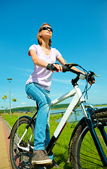 Image showing Young woman is sitting on her bicycle