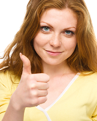 Image showing Woman is showing thumb up gesture