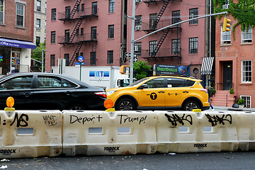 Image showing Graffiti slogan - Deport Trump! - on a traffic barrier on 7th Av