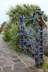 Image showing Weathered, locked blue gate covered with peeling blue paint