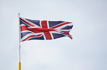 Image showing Union Jack flag representing United Kingdom, flies against a lig